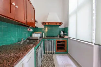 a kitchen with green tiled walls and a sink at Plaza Del Mar Casa vacanza Mondello in Palermo