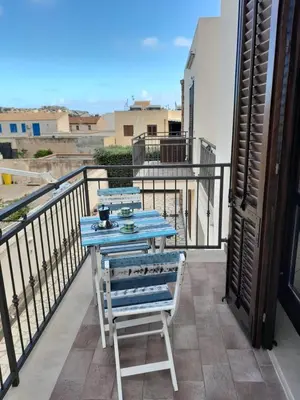 a blue table and a chair on a balcony at Relax beach San Vito lo Capo in San Vito lo Capo