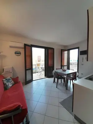 a living room with a red couch and a table at Relax beach San Vito lo Capo in San Vito lo Capo