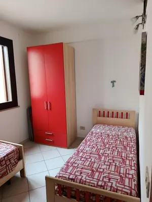 a bedroom with a red cabinet and a bed at Relax beach San Vito lo Capo in San Vito lo Capo