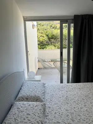 a bedroom with a bed and a sliding glass door at CasaLavinaro in Castellammare del Golfo