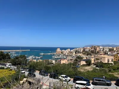 a city with cars parked in a parking lot at CasaLavinaro in Castellammare del Golfo