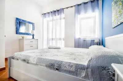 a bedroom with a large bed with blue walls and a window at La Casetta del Vicolo in Palermo