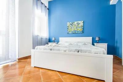 a blue bedroom with a white bed in a blue wall at La Casetta del Vicolo in Palermo