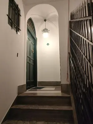 a hallway with a green door in a building at B&B Duca di Maqueda nel pieno centro dell citta' a 5 minuti dalla stazione degli autobus e dei treni in Palermo