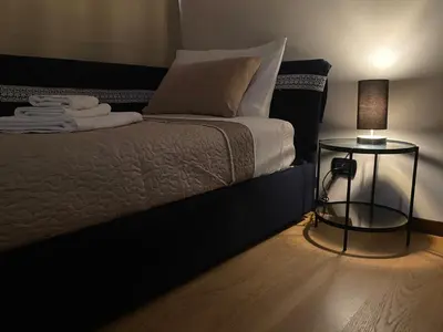 a bedroom with a bed with a lamp and a side table at B&B Duca di Maqueda nel pieno centro dell citta' a 5 minuti dalla stazione degli autobus e dei treni in Palermo