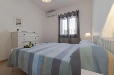 a bedroom with a bed and a dresser and a window at Appartamento La Loggetta a pochi metri dalla spiaggia di San Vito Lo Capo in San Vito lo Capo