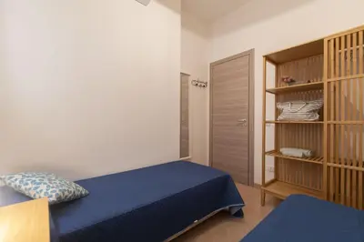a bedroom with a blue bed and a book shelf at Appartamento La Loggetta a pochi metri dalla spiaggia di San Vito Lo Capo in San Vito lo Capo