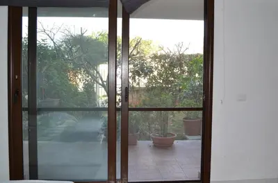 an open glass door to a patio with potted plants at Cale e Calle in Terrasini