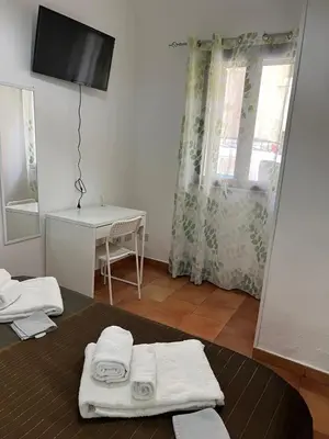 a room with a bed with towels and a television at Casa Fico D'India in Cinisi