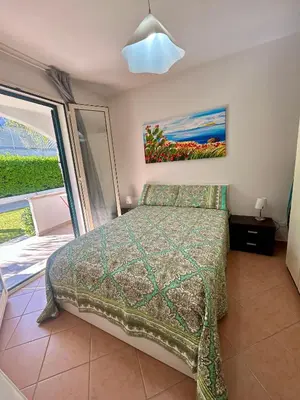 a bedroom with a bed and a painting on the wall at casa NiKa a 150 mt dal mare in Isola delle Femmine