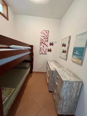 a room with two bunk beds and paintings on the wall at casa NiKa a 150 mt dal mare in Isola delle Femmine