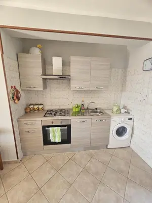 a kitchen with a stove and a washing machine at David's Apartment in San Vito lo Capo