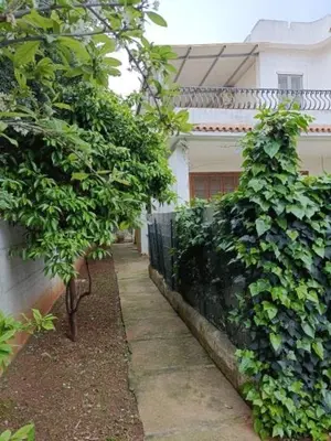 a sidewalk next to a building with trees and a fence at Appartamento Casa Florio Mondello in Palermo