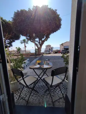 a table and chairs on a patio with a tree at Sunrise in Santa Flavia