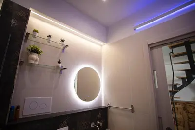 a bathroom with a round mirror and a sink at Sunrise in Santa Flavia