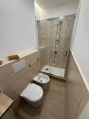 a bathroom with a toilet and a shower and a sink at Bart165 Luxury Rooms in Palermo