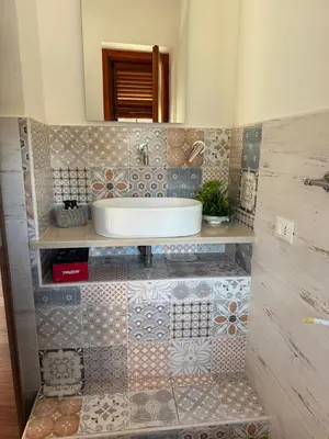 a bathroom with a sink on a tiled wall at Risvegliarsi a Danisinni in Palermo