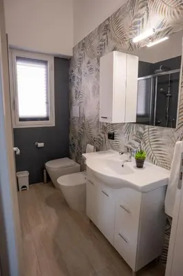 a bathroom with a white sink and a toilet at Harmony Lux in Bagheria