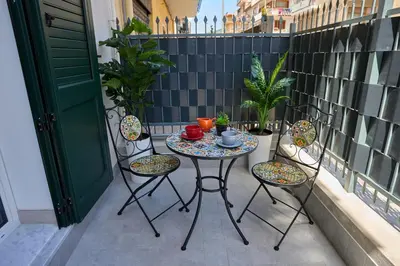 a small table and chairs on a balcony at Harmony Lux in Bagheria