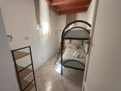 a small room with a bunk bed and a ladder at Arco Apartment in Bagheria