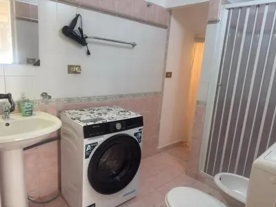 a washing machine in a bathroom with a sink at Arco Apartment in Bagheria