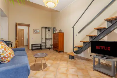 a living room with a blue couch and a tv at Prospettiva Ballarò - Sotto la cupola in Palermo