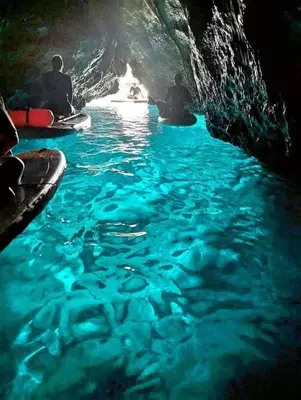two people sitting on kayaks in the water in a cave at Home sweet home in Santa Flavia