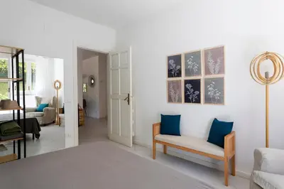 a living room with white walls and blue pillows at Donna Amalia villa in Mondello in Palermo