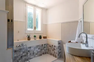 a bathroom with a tub and a sink and a window at Donna Amalia villa in Mondello in Palermo