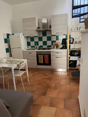 a kitchen with white cabinets and a table and a table and a kitchen at Tampasiando Limoni in Cinisi