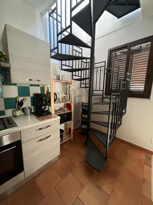 a kitchen with a spiral staircase in a kitchen at Tampasiando Limoni in Cinisi
