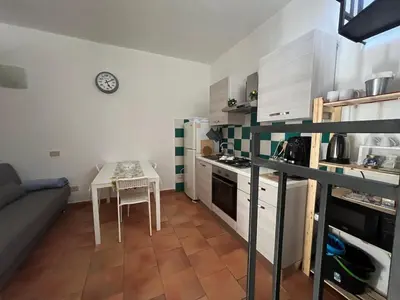 a small kitchen with a table and a small kitchen with a stove at Tampasiando Limoni in Cinisi
