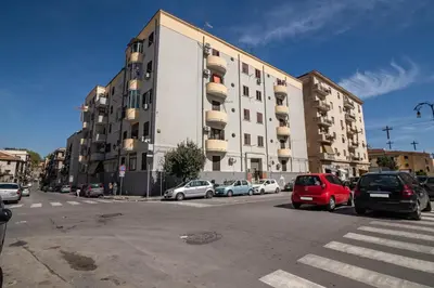 a large building with cars parked in front of it at GuestHost - Ballarò Flat dei Sovrani x6 in Palermo