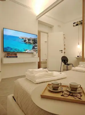 a bedroom with a large tv on the wall at Cappuccetto Rosso Sweet Apartment Palermo in Palermo
