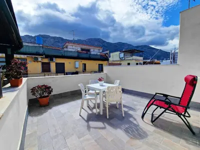 a patio with a table and chairs on a roof at Casa Mo' in Isola delle Femmine