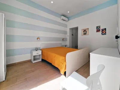 a bedroom with a bed and striped walls at Casa Mo' in Isola delle Femmine