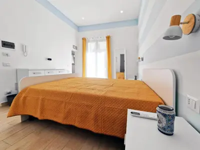 a bedroom with a bed with an orange bedspread at Casa Mo' in Isola delle Femmine