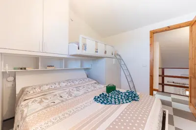 a small room with a bed with a ladder and a staircase at Clizia Holiday in Campofelice di Roccella