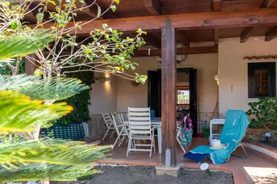 a patio with two chairs and a table and chairs at Clizia Holiday in Campofelice di Roccella