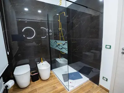 a bathroom with a toilet and a glass shower at Amuri Luxury Palermo centro in Palermo