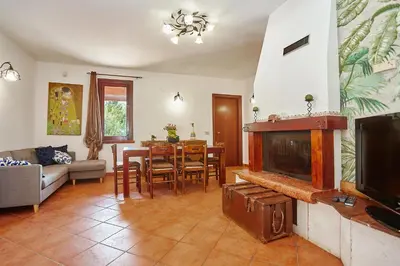 a living room with a fireplace and a dining room at villa oasi scopello in Castellammare del Golfo
