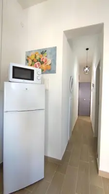 a kitchen with a microwave on top of a refrigerator at Isola delle Femmine vacation home in Isola delle Femmine
