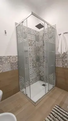 a shower with glass doors in a bathroom at Isola delle Femmine vacation home in Isola delle Femmine