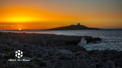 a lighthouse on an island in the ocean at sunset at Isola delle Femmine vacation home in Isola delle Femmine