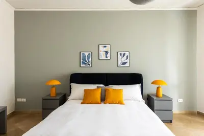 a bedroom with a white bed with two orange lamps at Vittorio Veneto Apartment by Wonderful Italy in Palermo