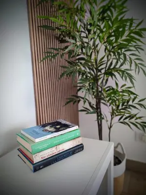 a stack of books sitting on a table next to a plant at La casa di Zucchero in Monreale