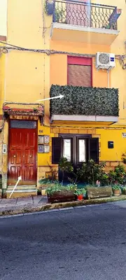 a yellow building with a red door on a street at La casa di Zucchero in Monreale
