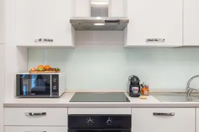 a kitchen with a microwave and a bowl of fruit at Casta Diva Fervore Apartments Self Check-in in Palermo