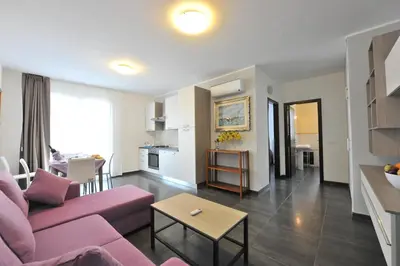 a living room with a pink couch and a table at Case Mistretta in Altavilla Milicia